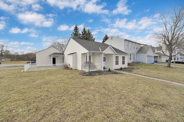 view of front of property featuring roof with shingles, fence, and a front yard