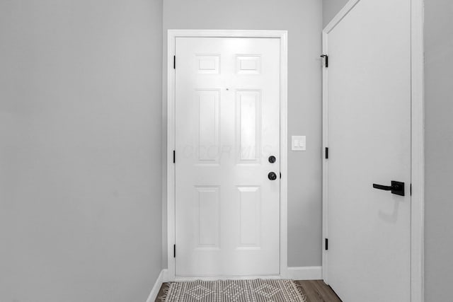 doorway with baseboards and wood finished floors