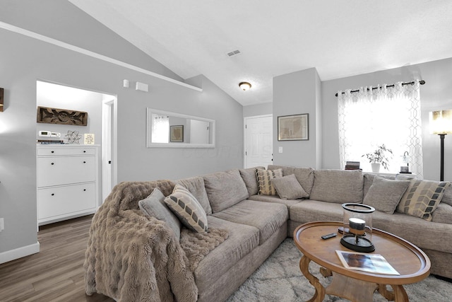 living area featuring baseboards, visible vents, vaulted ceiling, and wood finished floors