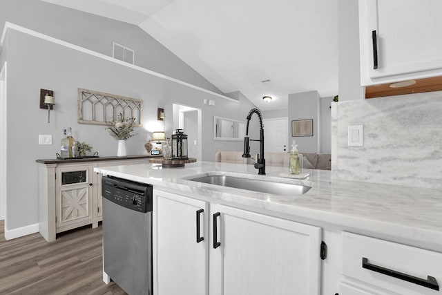 kitchen with visible vents, stainless steel dishwasher, white cabinets, vaulted ceiling, and a sink