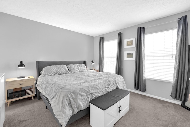 bedroom featuring baseboards, a textured ceiling, and light colored carpet