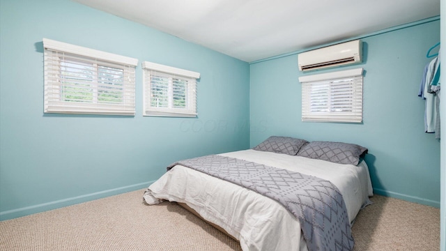 bedroom with carpet, baseboards, and a wall mounted AC