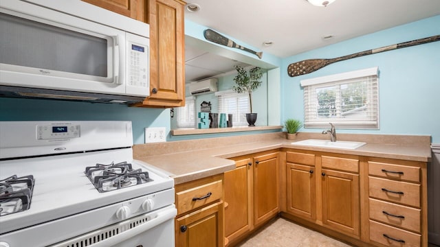 kitchen with a wall unit AC, white appliances, light countertops, and a sink