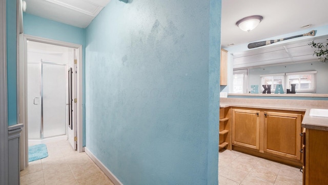 hall with light tile patterned floors, baseboards, and a sink