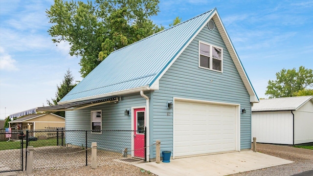 view of front of property featuring a garage, metal roof, fence, and a gate