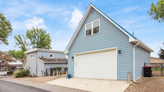 view of home's exterior with a detached garage and fence