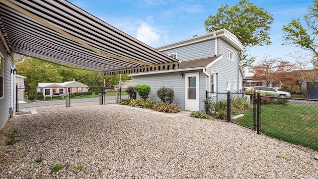 view of property exterior with a gate, fence, and a yard