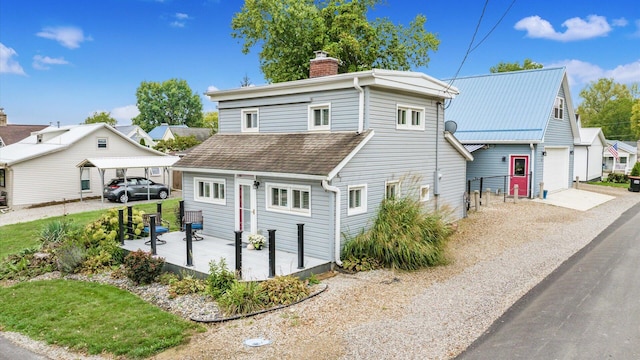 view of front of property with gravel driveway, a garage, a chimney, and a shingled roof