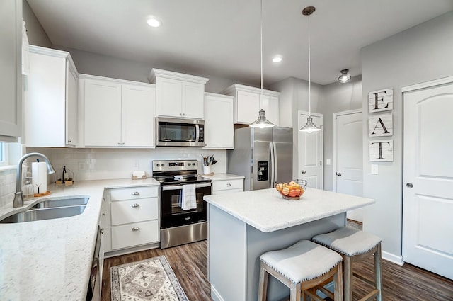 kitchen with a center island, tasteful backsplash, appliances with stainless steel finishes, dark wood-type flooring, and a sink