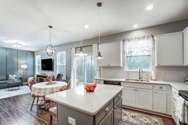 kitchen featuring dark wood-type flooring, a sink, open floor plan, decorative backsplash, and a center island