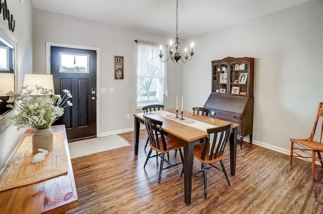 dining room featuring baseboards, an inviting chandelier, and wood finished floors