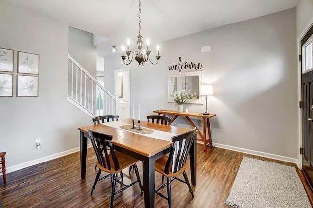 dining space featuring stairs, baseboards, a chandelier, and wood finished floors