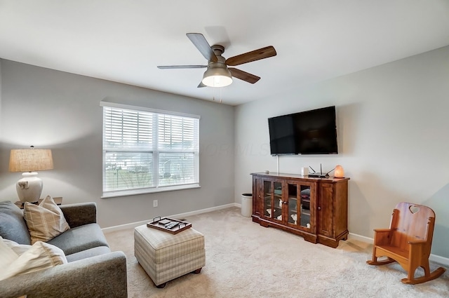 living room featuring carpet floors, baseboards, and a ceiling fan