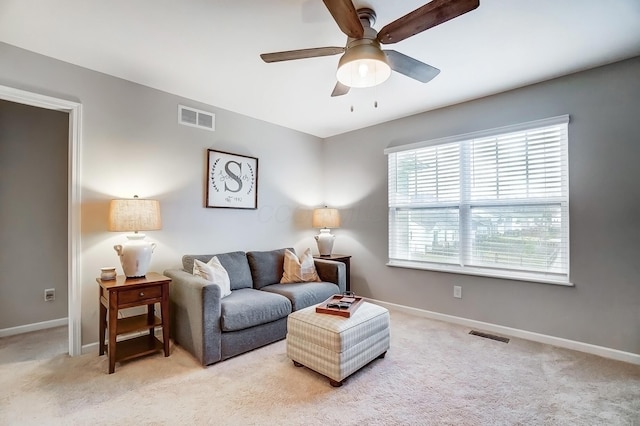 living room with light colored carpet, visible vents, and baseboards