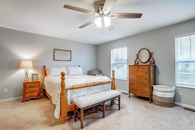 bedroom with light colored carpet, multiple windows, and visible vents