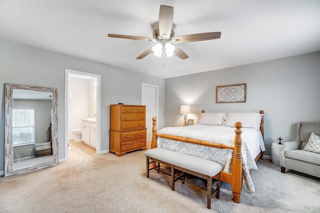 bedroom with baseboards, ceiling fan, connected bathroom, and light colored carpet