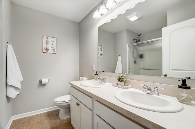 full bathroom featuring a stall shower, a sink, toilet, and baseboards