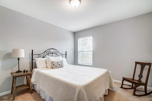 bedroom featuring light carpet and baseboards