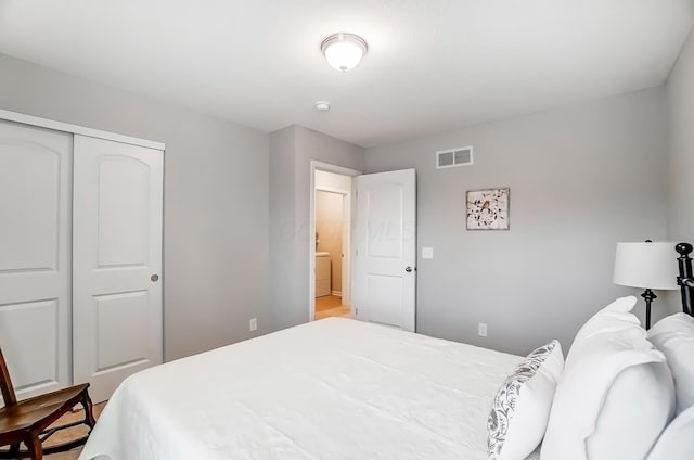 bedroom featuring washer / clothes dryer, a closet, and visible vents