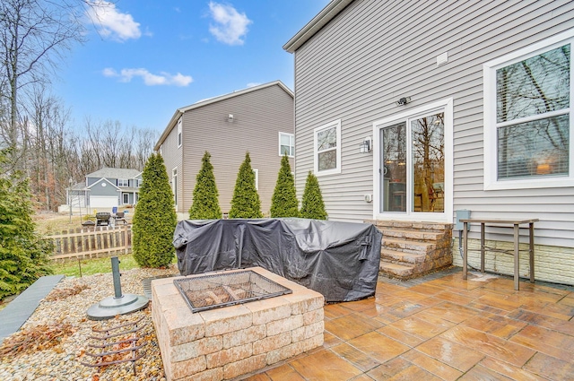 view of patio featuring a fire pit, grilling area, and fence