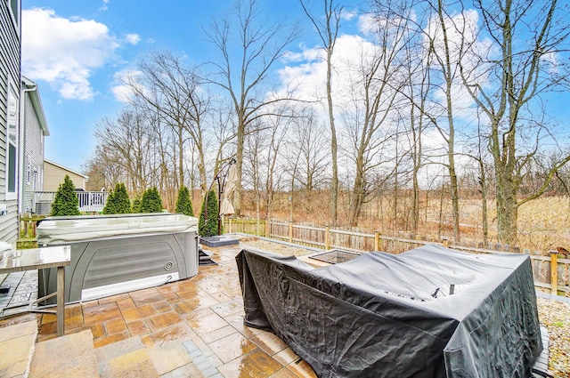 view of patio / terrace featuring fence and a hot tub