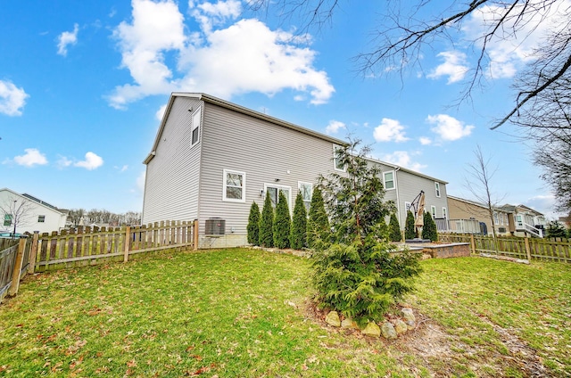 back of house with a lawn, a fenced backyard, and central air condition unit