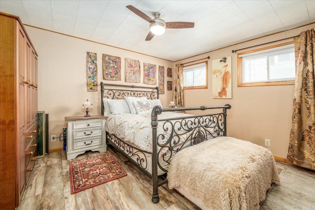 bedroom featuring wood finished floors, baseboards, and ceiling fan