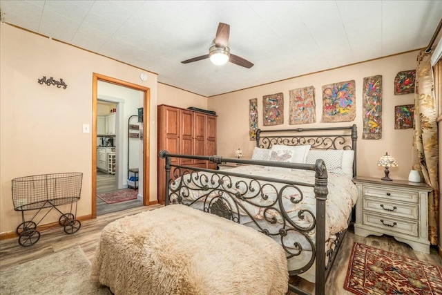 bedroom featuring baseboards, a ceiling fan, and wood finished floors