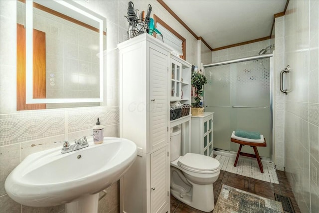 bathroom with visible vents, a sink, a shower stall, tile walls, and toilet