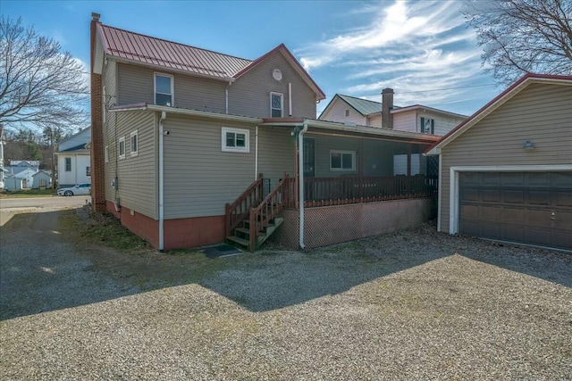 back of property featuring a porch, metal roof, and a garage