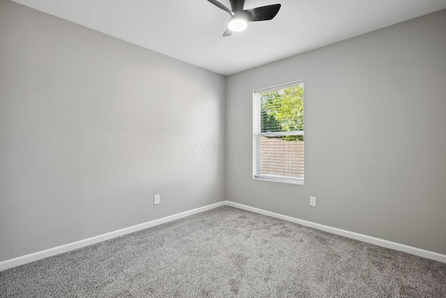 carpeted spare room with ceiling fan and baseboards