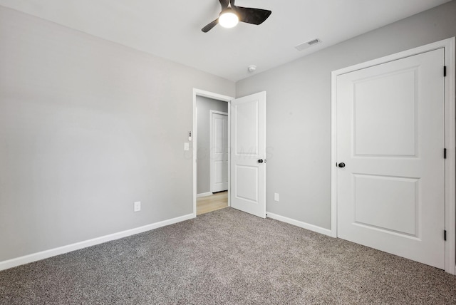 unfurnished bedroom featuring carpet floors, baseboards, visible vents, and ceiling fan