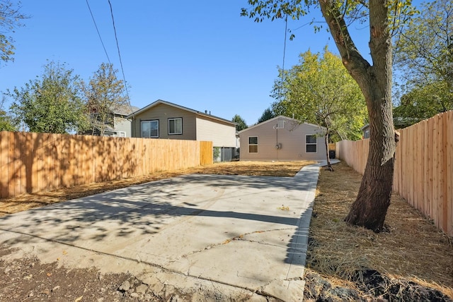 back of house featuring driveway and fence private yard