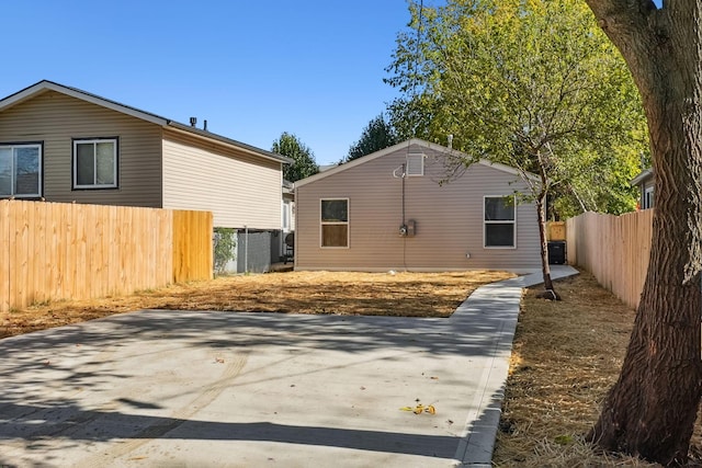 rear view of house featuring cooling unit and fence