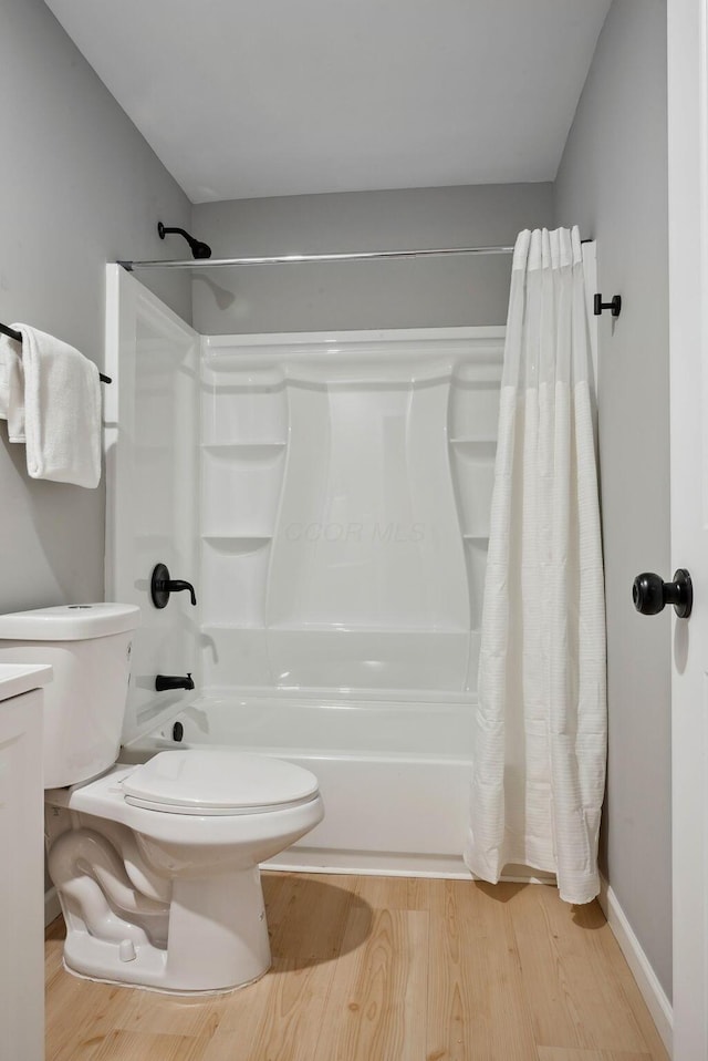 full bath with vanity, shower / bathtub combination with curtain, toilet, and wood finished floors