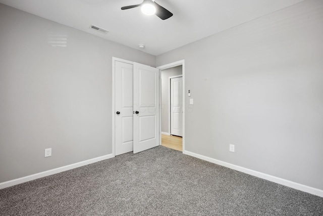 unfurnished bedroom featuring ceiling fan, carpet, visible vents, and baseboards