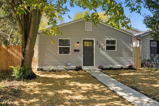 bungalow-style home featuring fence