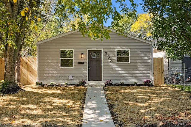 bungalow-style house with fence