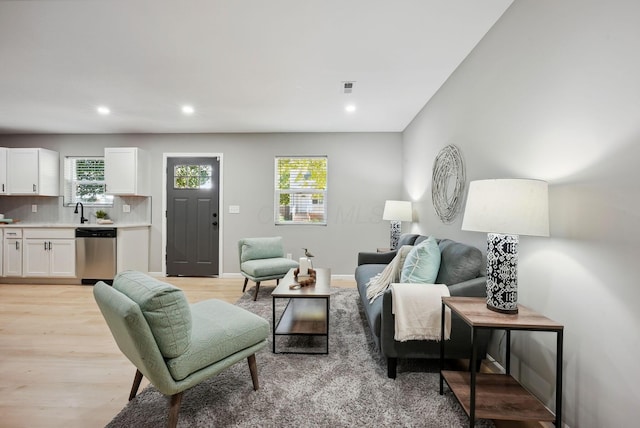 living room with a healthy amount of sunlight, recessed lighting, and light wood-style floors