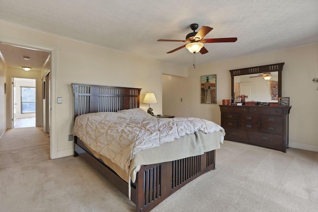 bedroom featuring light colored carpet, baseboards, and a textured ceiling