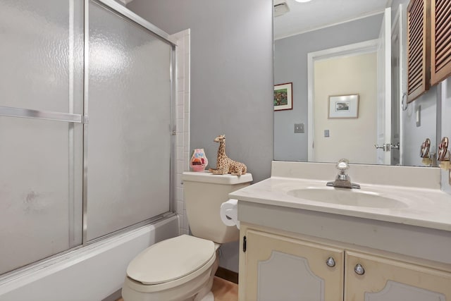 bathroom featuring vanity, toilet, and shower / bath combination with glass door