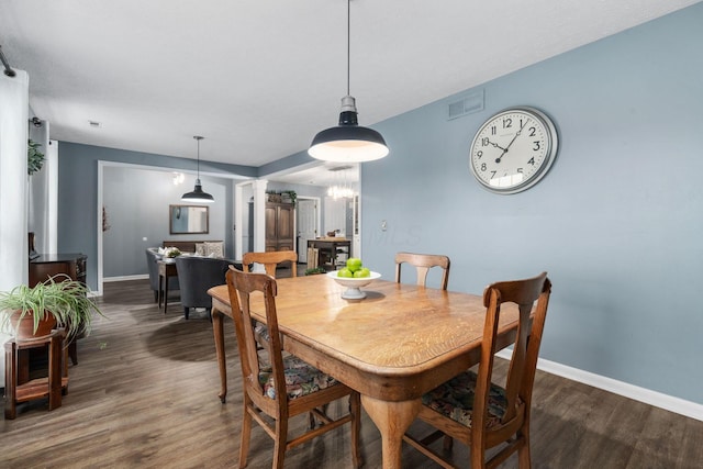 dining room with baseboards, visible vents, ornate columns, and wood finished floors