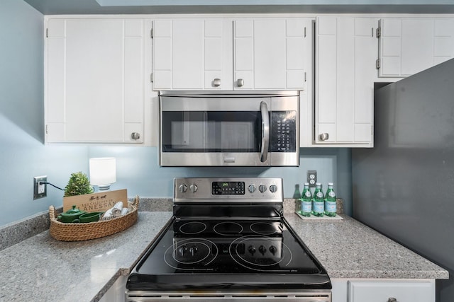 kitchen featuring appliances with stainless steel finishes, light countertops, and white cabinetry