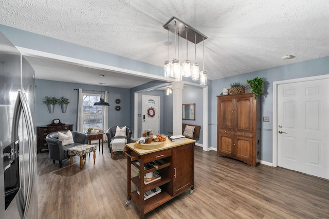 dining space featuring a textured ceiling, baseboards, and wood finished floors