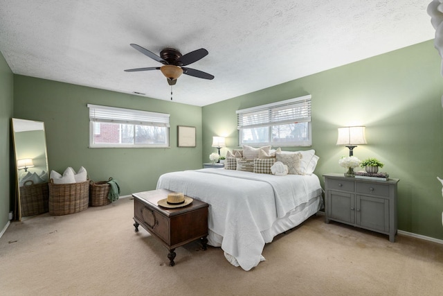 bedroom featuring ceiling fan, multiple windows, and light colored carpet