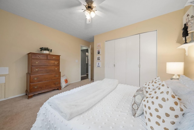 carpeted bedroom with a closet, ceiling fan, and baseboards