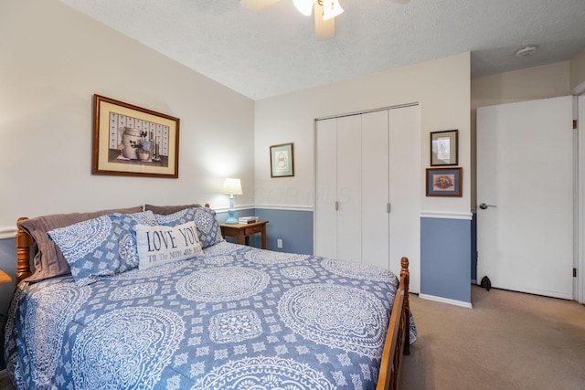 carpeted bedroom with a textured ceiling, a ceiling fan, and a closet