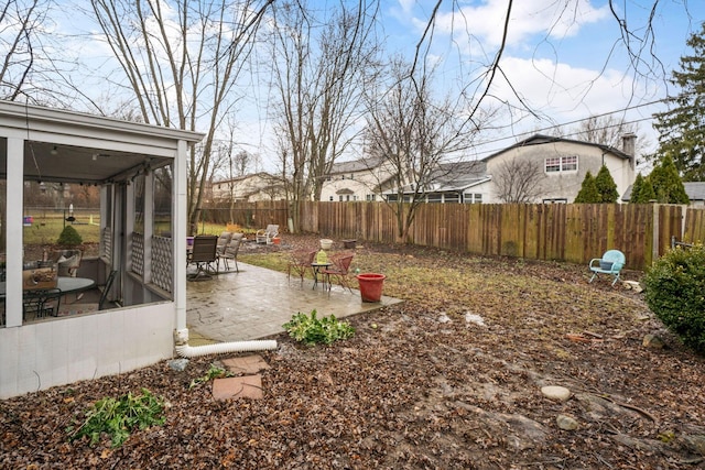 view of yard with a sunroom, a fenced backyard, and a patio