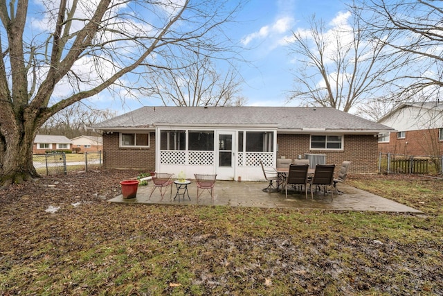 back of property with brick siding, a patio, a sunroom, a gate, and fence private yard