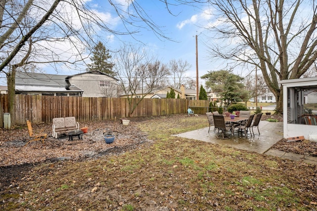 view of yard with a patio area, a fenced backyard, and a sunroom